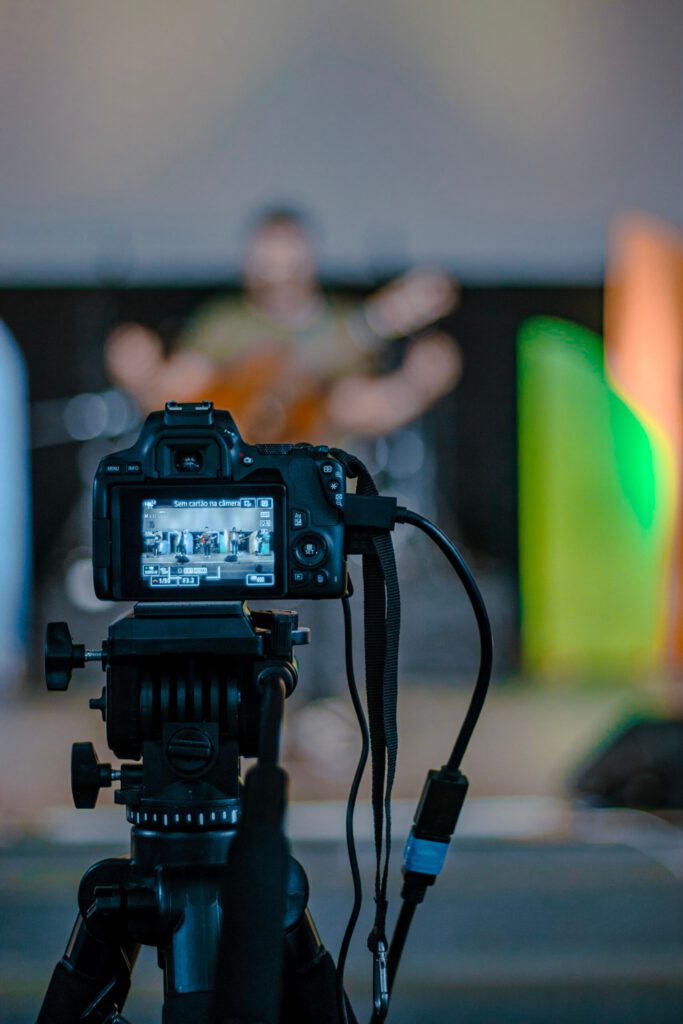 Digital camera setup capturing a live music performance with colorful stage lights.